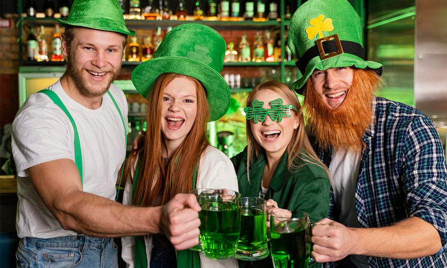 4 personnes célébrant la Saint-Patrick en trinquant avec une bière verte